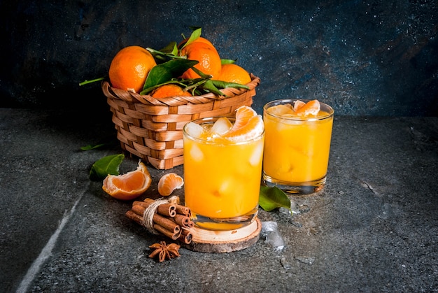 Würziges Wintertangerine Cocktail mit Wodka, frischen Mandarinen, Zimt und Anis, auf dunklem Hintergrund, Kopienraum