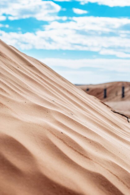 Wüstensanddüne gegen blauen Himmel mit weißen Wolken in der Sahara in Tunesien