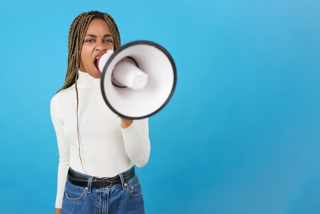 Wütende afrikanische Frau protestiert, während sie einen Lautsprecher benutzt