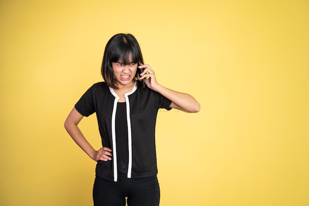 Wütende asiatische Frau, die mit einem Handy telefoniert