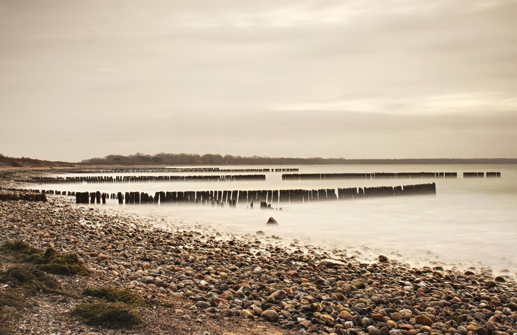 Foto wütende sonnenuntergang über dem meer strand schäumiges wasserniveau donne von großen wellen schlagen in den alten wellenbrecher