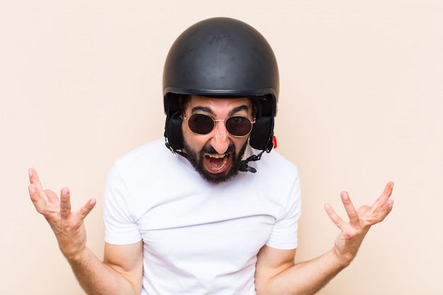 Wütender Ausdruck des jungen kühlen bärtigen Mannes mit einem Helm