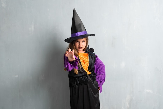 Wütendes kleines Mädchen gekleidet als Hexe für Halloween-Feiertage