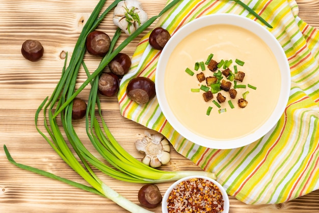 Wunderbare Cremesuppe von Kastanien auf einem Holztisch.