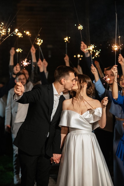 Wunderkerzen bei der Hochzeit des Brautpaares in den Händen freudiger Gäste