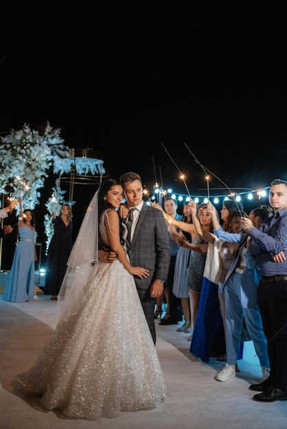 Wunderkerzen bei der Hochzeit des Brautpaares in den Händen freudiger Gäste