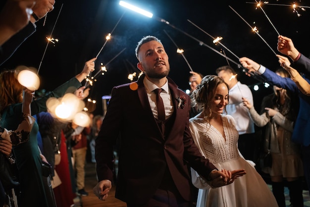 Wunderkerzen bei der Hochzeit des Brautpaares in den Händen freudiger Gäste