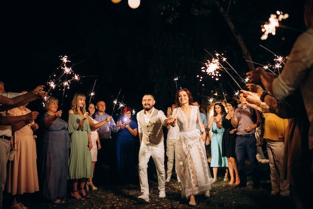 Wunderkerzen bei der Hochzeit des Brautpaares in den Händen freudiger Gäste