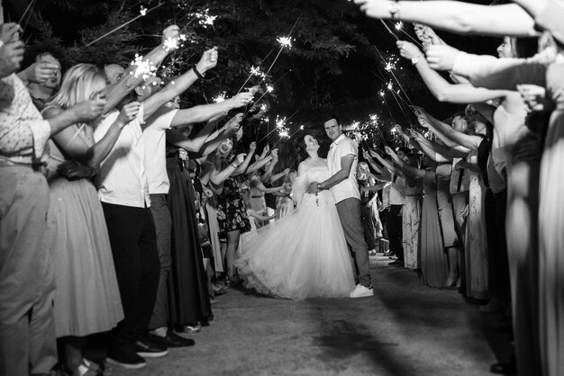 Wunderkerzen bei der Hochzeit des Brautpaares in den Händen freudiger Gäste