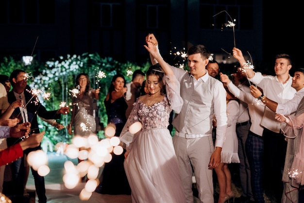 Wunderkerzen bei der Hochzeit des Brautpaares in den Händen freudiger Gäste