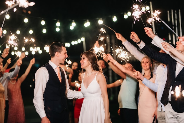 Foto wunderkerzen bei der hochzeit des brautpaares in den händen freudiger gäste