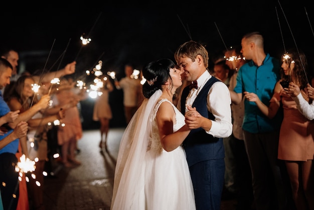 Wunderkerzen bei der Hochzeit des Brautpaares in den Händen freudiger Gäste