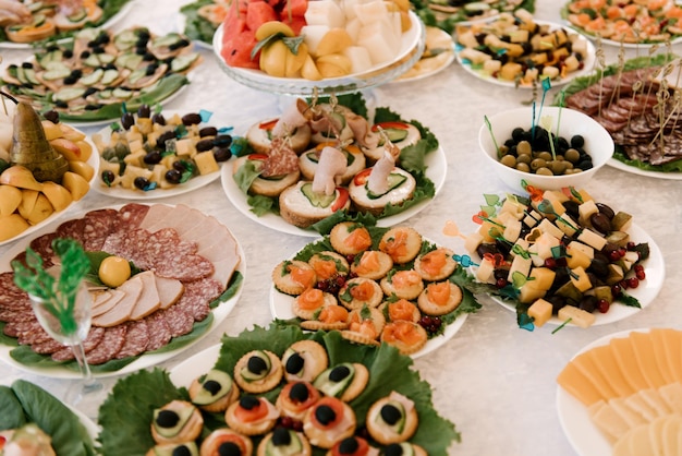 Wunderschön dekorierter Catering-Banketttisch mit verschiedenen Snacks und Vorspeisen mit Sandwich-Kaviar und frischen Früchten auf Firmenfeiern oder Hochzeitsfeiern