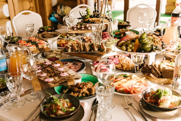 Wunderschön dekorierter Catering-Banketttisch mit verschiedenen Snacks und Vorspeisen mit Sandwich-Kaviar und frischen Früchten auf Firmenfeiern oder Hochzeitsfeiern