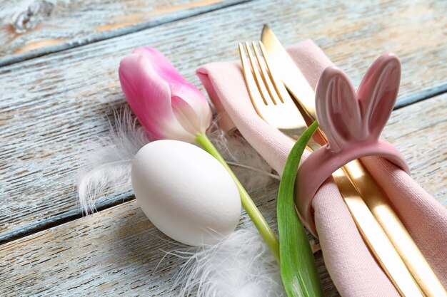 Wunderschön dekoriertes Besteck für den Ostertisch auf Holzhintergrund