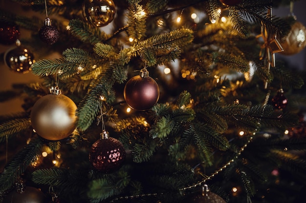 Wunderschön geschmückter Weihnachtsbaum closeup Fröhliche Lichter von Girlanden auf einem Weihnachtsbaum in einem dunklen Raum