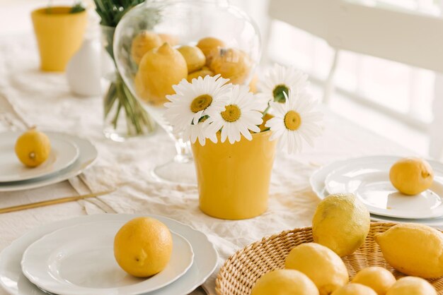 Wunderschön servierter weißer Frühlingssommertisch mit vielen Zitronen und Kamille