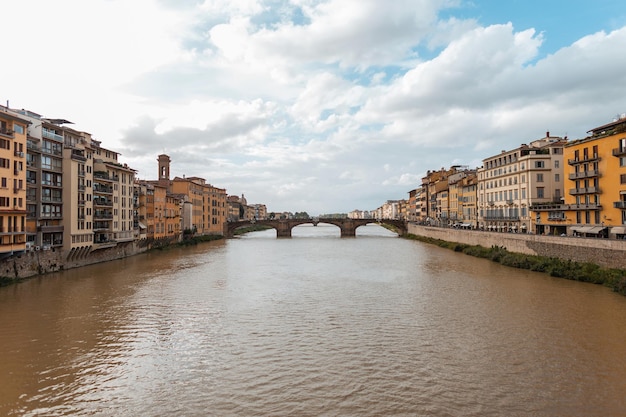 Wunderschöne alte Stadt mit einem Fluss, einer Brücke und alten Häusern entlang des Flusses in Florenz, Italien