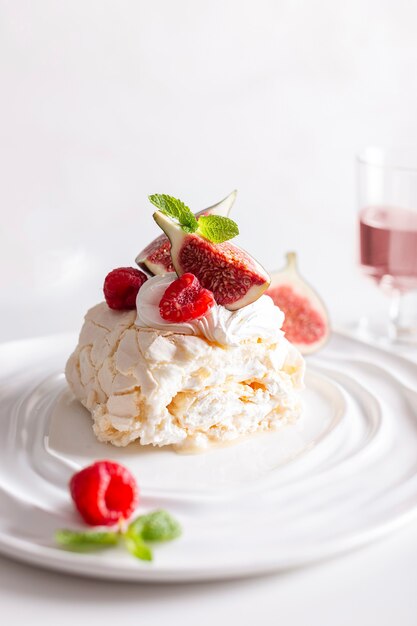 Wunderschöne Baiserrolle namens Pavlova, dekoriert mit Feigen und Himbeeren