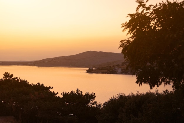 Foto wunderschöne farben des sonnenuntergangs über den bergen auf der insel pag in kroatien. leere inseln am abend über dem sommersonnenuntergang an der adria