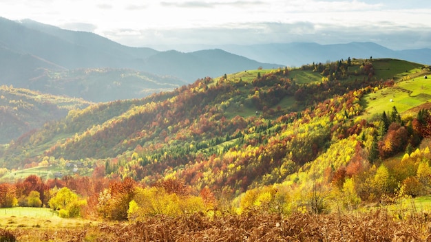 Wunderschöne Herbstlandschaft mit wunderschönem blauen Himmel und majestätischen Wolken Sonnenuntergang im Wald Schöne Herbstsaison Waldberg Sonnenuntergang orange Farben Spiritualität Inspiration Urlaubskonzept