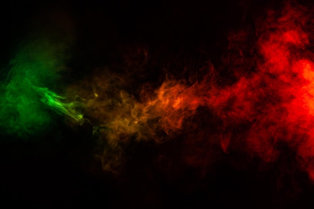Wunderschöne horizontale Rauchsäule im neonhellen Licht von Rot, Grün, Gelb und Orange auf einem schwarzen Hintergrund, der aus dem Dampf ausgeatmet wird. Schönes Muster zum Drucken und Hintergrund aus farbigen Wellen