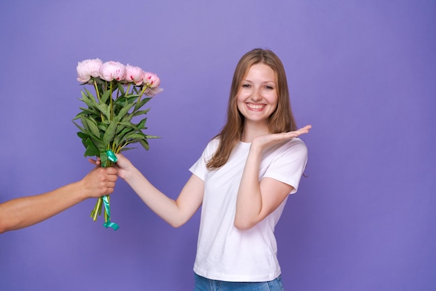 Wunderschöne junge Dame freut sich über den Pfingstrosenstrauß zum Frauentag