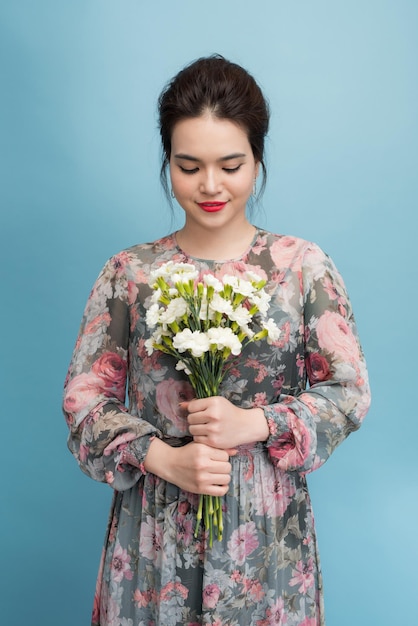 Wunderschöne junge Frau in niedlichem Retro-Kleid auf blauem Hintergrund