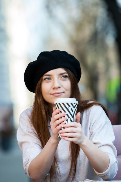 Wunderschöne junge Frau mit Tasse Kaffee in der Stadtstraße