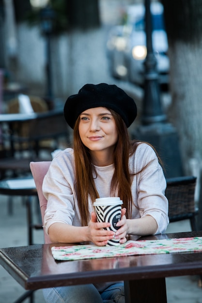 Wunderschöne junge Frau mit Tasse Kaffee in der Stadtstraße