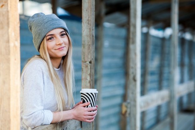 Wunderschöne junge Frau mit Tasse Kaffee in der Stadtstraße