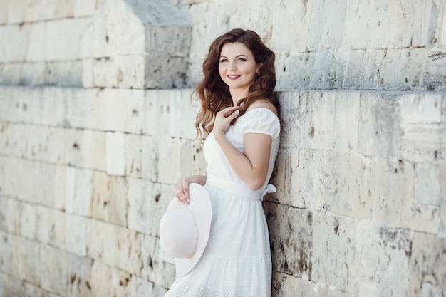 Wunderschöne junge Modellfrau mit perfektem Haar, das in der Stadt aufwirft. Sonniges Lifestyle-Modeporträt