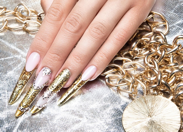 Wunderschöne lange Nägel im Golddesign mit Strass Nailart