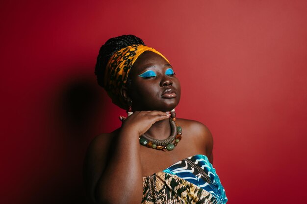 Foto wunderschöne plus-größe afrikanische frau mit schönem make-up in traditioneller kleidung, während sie steht