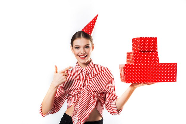 Wunderschöne schlanke junge Frau, die in einem gestreiften Rot mit roten Geschenkboxen trägt