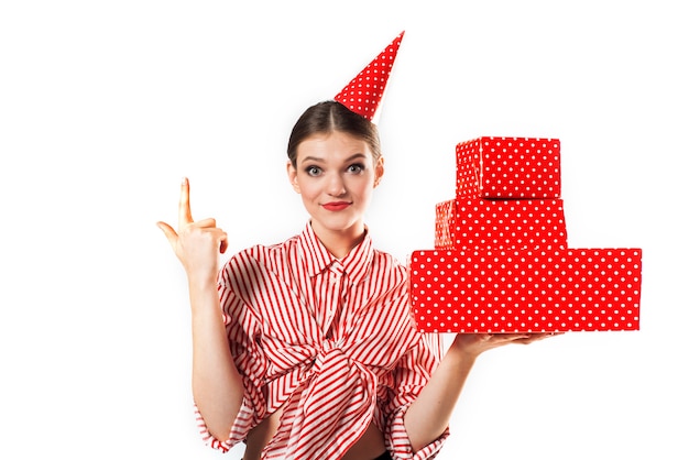 Wunderschöne schlanke junge Frau, die in einem gestreiften Rot mit roten Geschenkboxen trägt