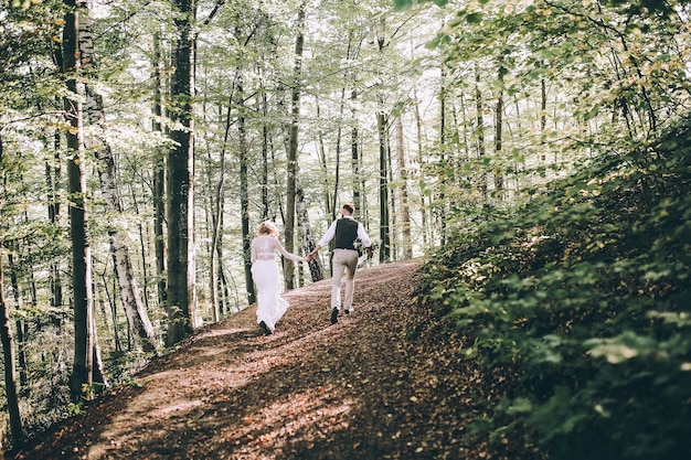 Wunderschöne wunderschöne Braut, die dem Bräutigam posiert und Spaß hat, Luxuszeremonie in den Bergen