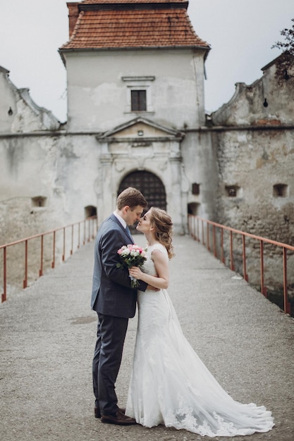 Wunderschöne wunderschöne Braut und Bräutigam küssen glückliches Hochzeitspaar umarmen und umarmen sich im alten Schloss glückliche romantische Momente Elopement-Konzept sinnlicher Liebesraum für Text