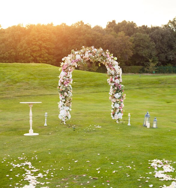 Wunderschöner Blumenbogen mit vielen kleinen lila rosa und weißen Blüten auf der grünen Wiese