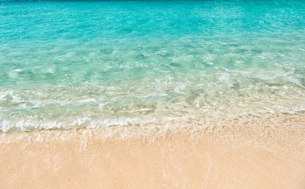 Wunderschöner Meeresblick auf die Meeresküste mit sauberem, welligem Brandungswasser am Sandstrandhorizont und bewölktem blauem Himmel am sonnigen Tag