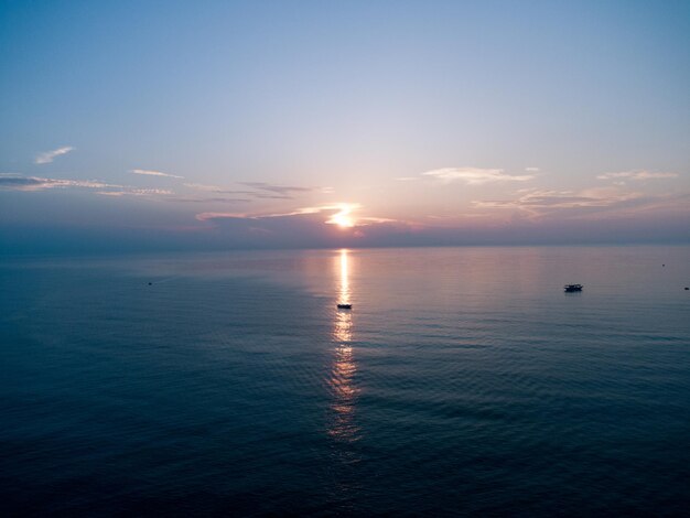 Foto wunderschöner sonnenaufgang am horizont des meeres, der die sonne im wasser des meeres reflektiert