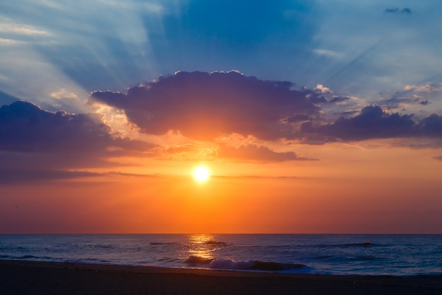 Wunderschöner Sonnenuntergang an einem leeren Sandstrand.