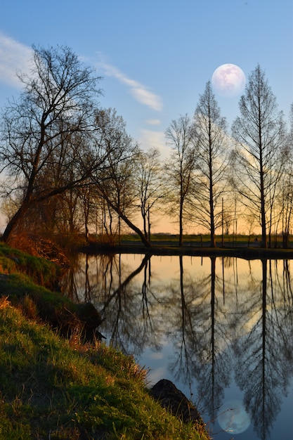 wunderschöner Vollmond auf dem Land spiegelt sich im Fluss