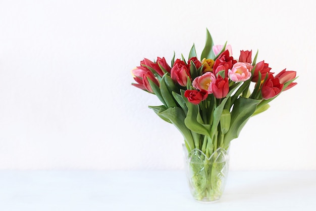 Wunderschönes Bouquet mit mehrfarbigen Tulpen im Vasen-Kopierraum