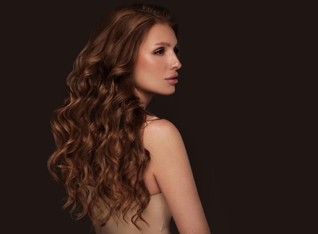 Wunderschönes braunhaariges Mädchen mit perfekt gelocktem Haar und klassischem Make-up Beauty Gesicht und Haare