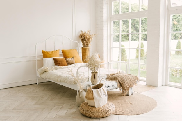 Wunderschönes helles Interieur im skandinavischen Stil, weißes Bett mit Fensterdekoration