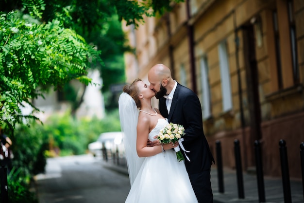 Wunderschönes Hochzeitspaar genießt einen sonnigen Tag in der Altstadt mit Architektur