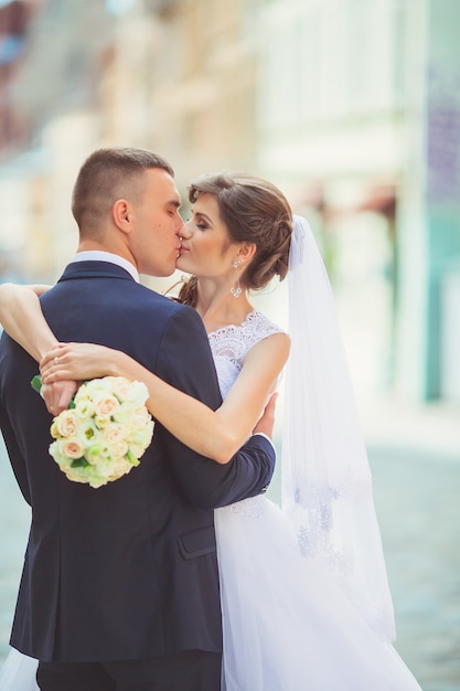 Wunderschönes Hochzeitspaar genießt einen sonnigen Tag in der Altstadt mit Architektur