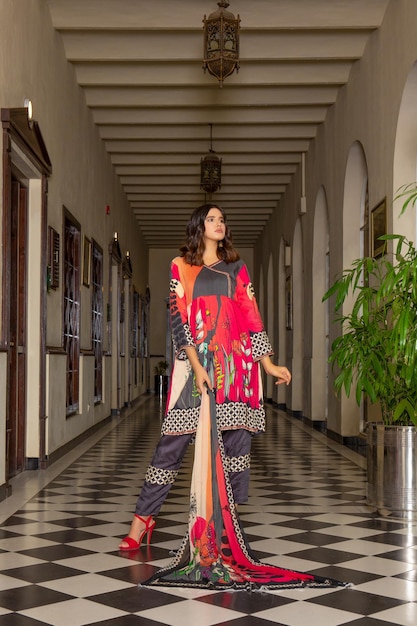 Wunderschönes Mädchen, das für ein Mode-Shooting in einem Hotelkorridor posiert und ein traditionelles Desi-Kleid trägt