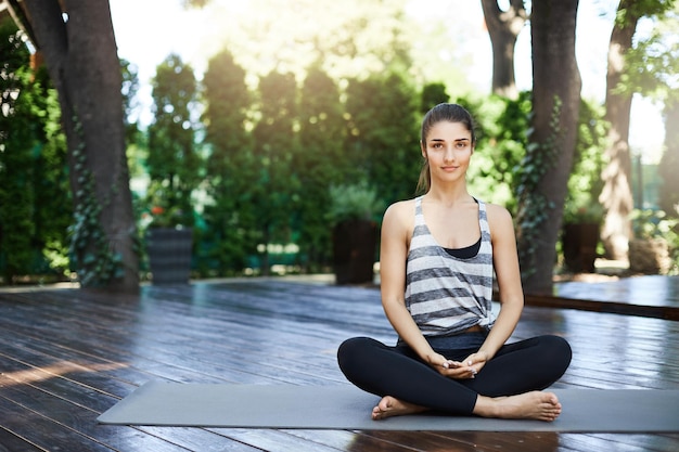 Wunderschönes Mädchen, das mitten im Yoga-Tempel meditiert und mit geöffneten Augen tief atmet Grundlegende Praxis